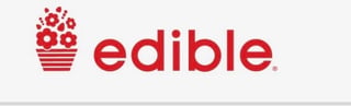 Edible Arrangements logo featuring a red basket icon with flowers and red text